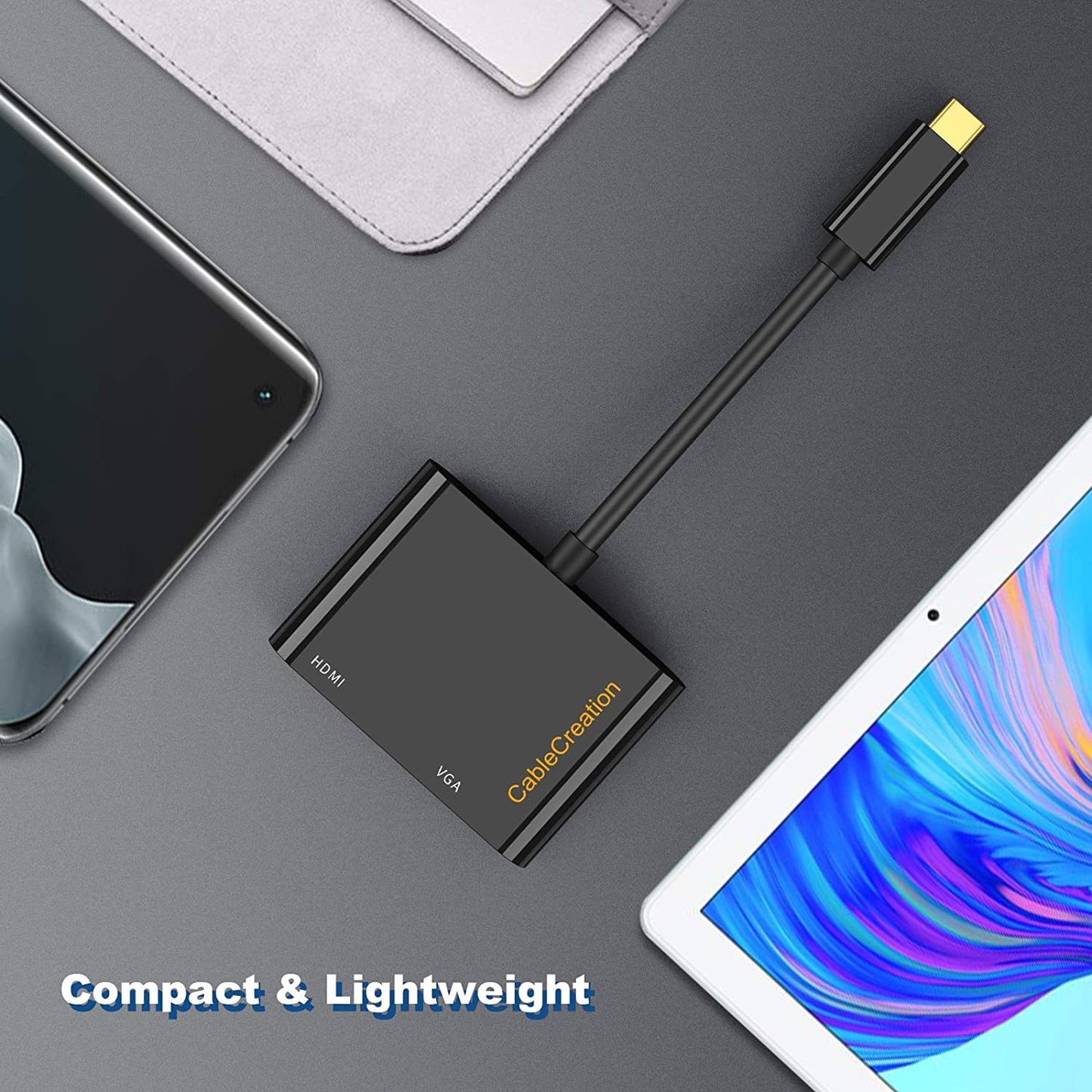USB-C to HDMI VGA adapter compact and lightweight design placed on desk beside smartphone and tablet