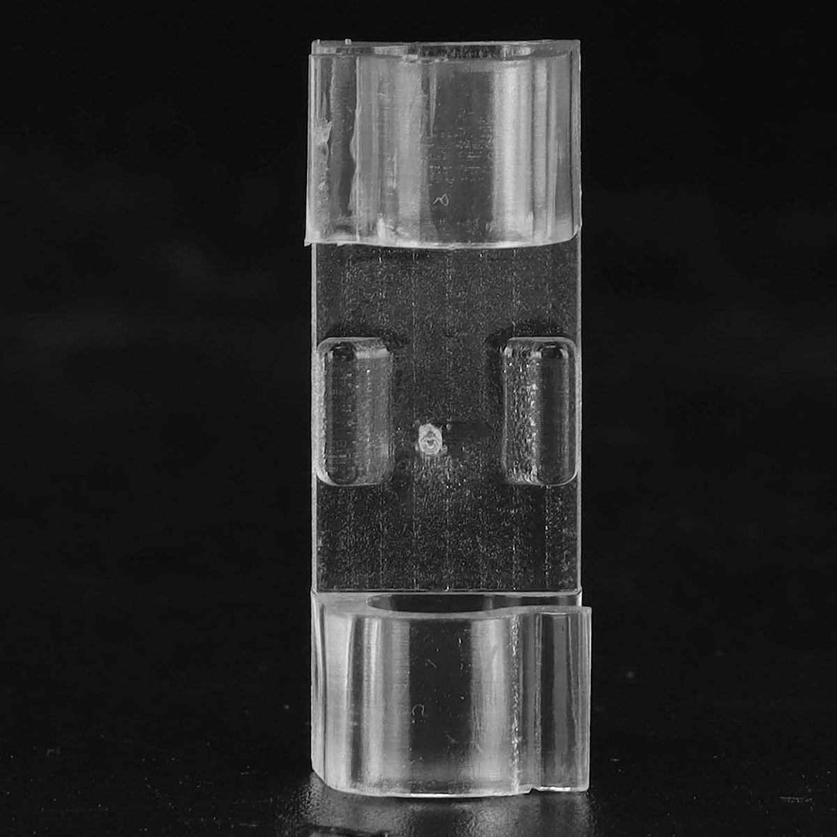 Clear plastic component on a black background