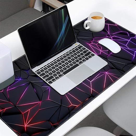 Laptop on a geometric patterned desk with a cup of coffee and mouse.