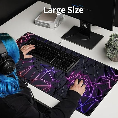 Person using a large desk mat with geometric design, sitting at a desk with computer setup.