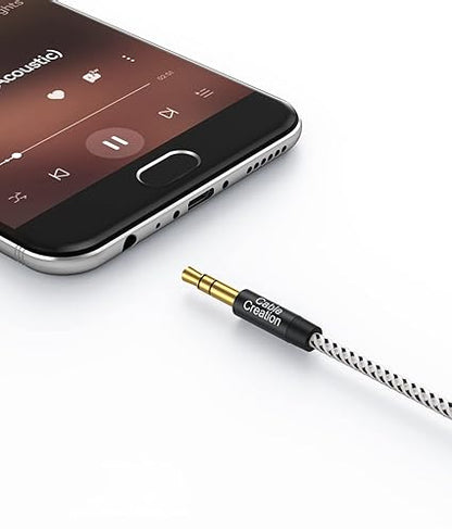 3.5mm aux cable gold-plated male connector with cotton braided jacket plugged into smartphone headphone jack for music streaming