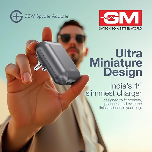 A hand holds a small gray 33W Spyder Adapter against a light blue background, with a blurred man wearing sunglasses in the background. The image includes promotional text and the GM Switch to a Better World logo.