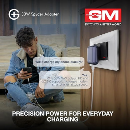 A promotional graphic for a 33W Spyder Adapter showing a man sitting on a couch and looking at his phone while a phone cable plugs into the adapter mounted on a wall. The image includes marketing text and the GM Switch to a Better World logo.