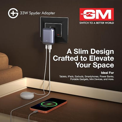A 33W Spyder Adapter by GM shown plugged into a wall outlet, with a smartphone charging on a wooden table below. The ad includes product text, the GM logo, and a clean interior setting.