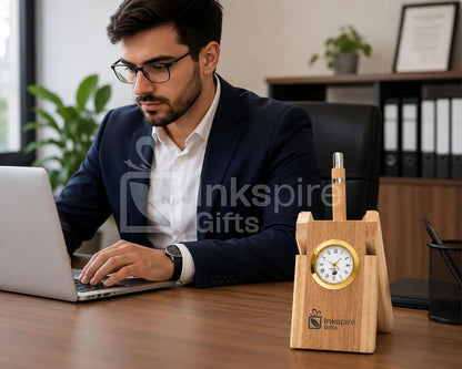 Businessman working on laptop next to wooden desk clock and pen stand organizer