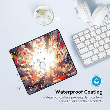 A rectangular gaming mouse pad with a colorful abstract paint explosion design and water droplets, shown on a light blue desk flat-lay with a keyboard, headphones, and a drink. Text on the image highlights its waterproof coating.