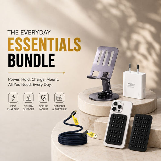A promotional bundle display for a phone accessories set on beige stone pedestals. The bundle includes a black phone stand, a white wall charger with the CMF logo, a black textured grip case, a white textured grip case, and a black cable with a yellow connector.