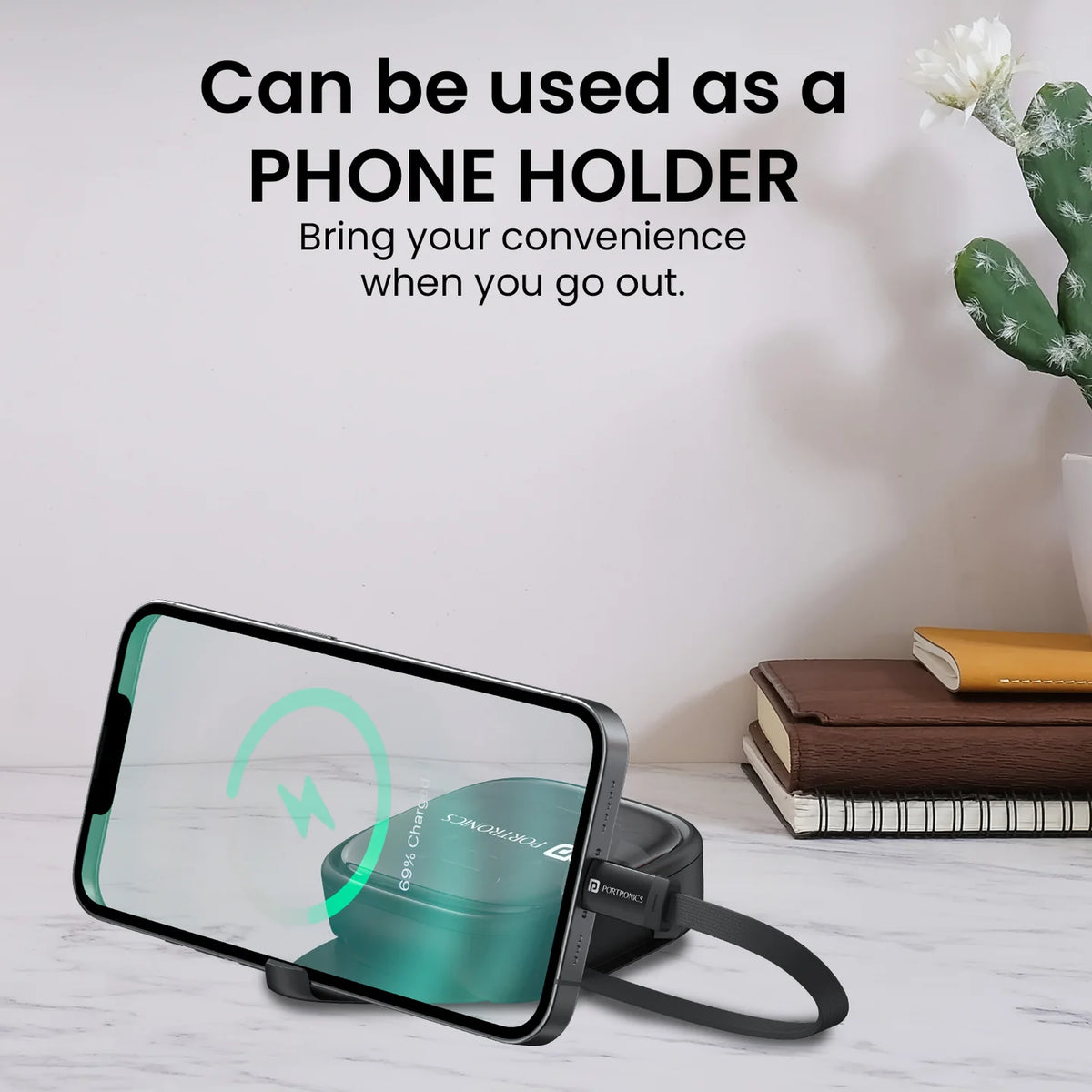 Phone holder with screen displaying a product, placed on a surface with books and a plant in the background.