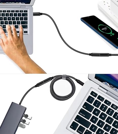 A black laptop extension cable shown plugged into a laptop, with a hand typing on the keyboard in the top half and the cable coiled beside the laptop in the bottom half. A smartphone and power adapter are also visible on a clean white background.