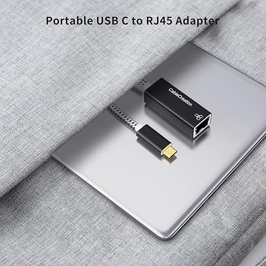 portable USB C to RJ45 Ethernet adapter connected to laptop inside travel bag